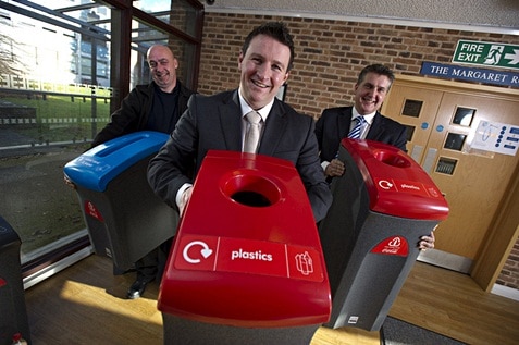 Three male employees holding recycle bins