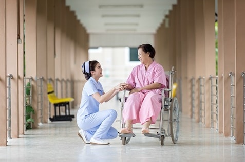 A nurse assisting an old woman