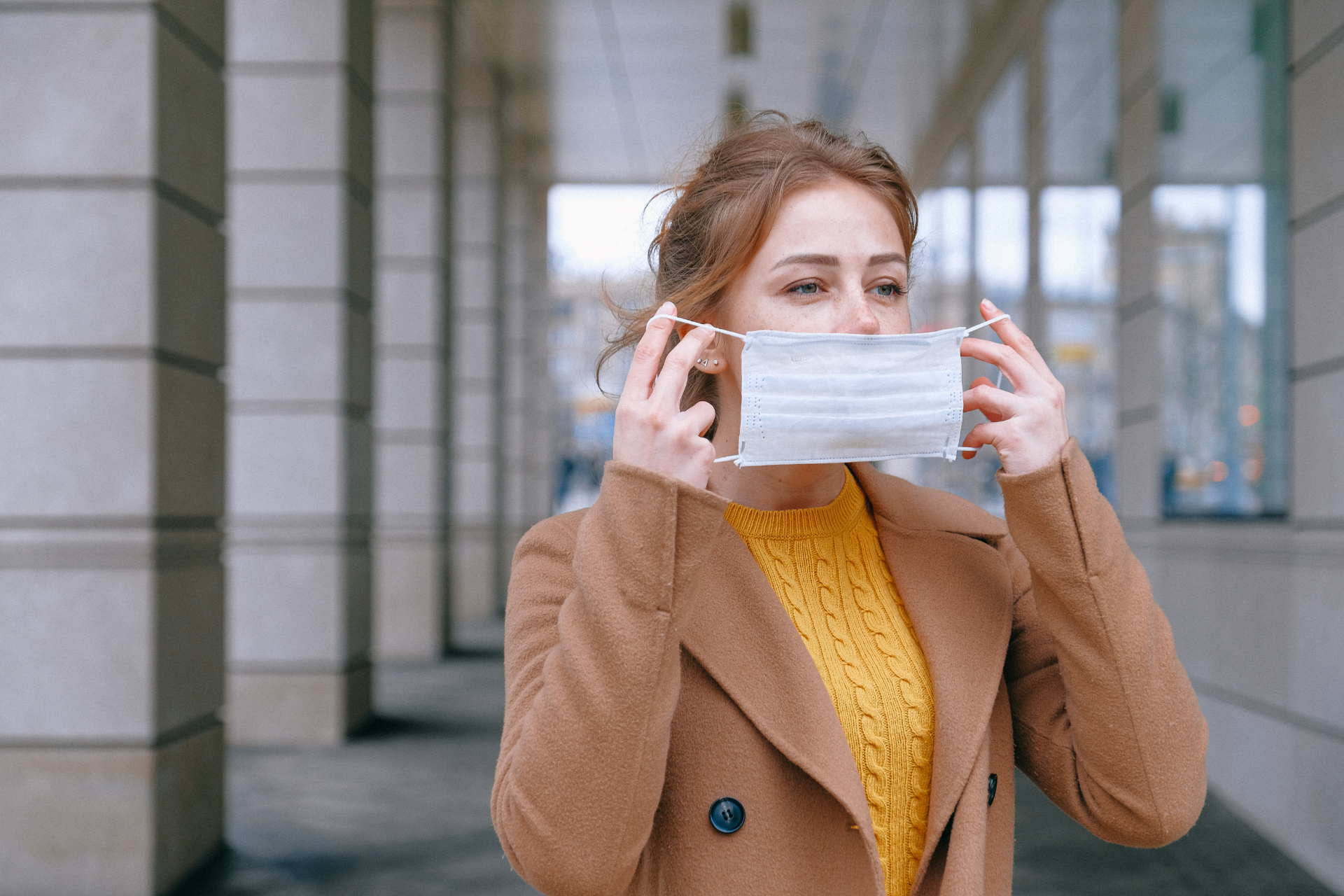 Woman putting on a mask while outside