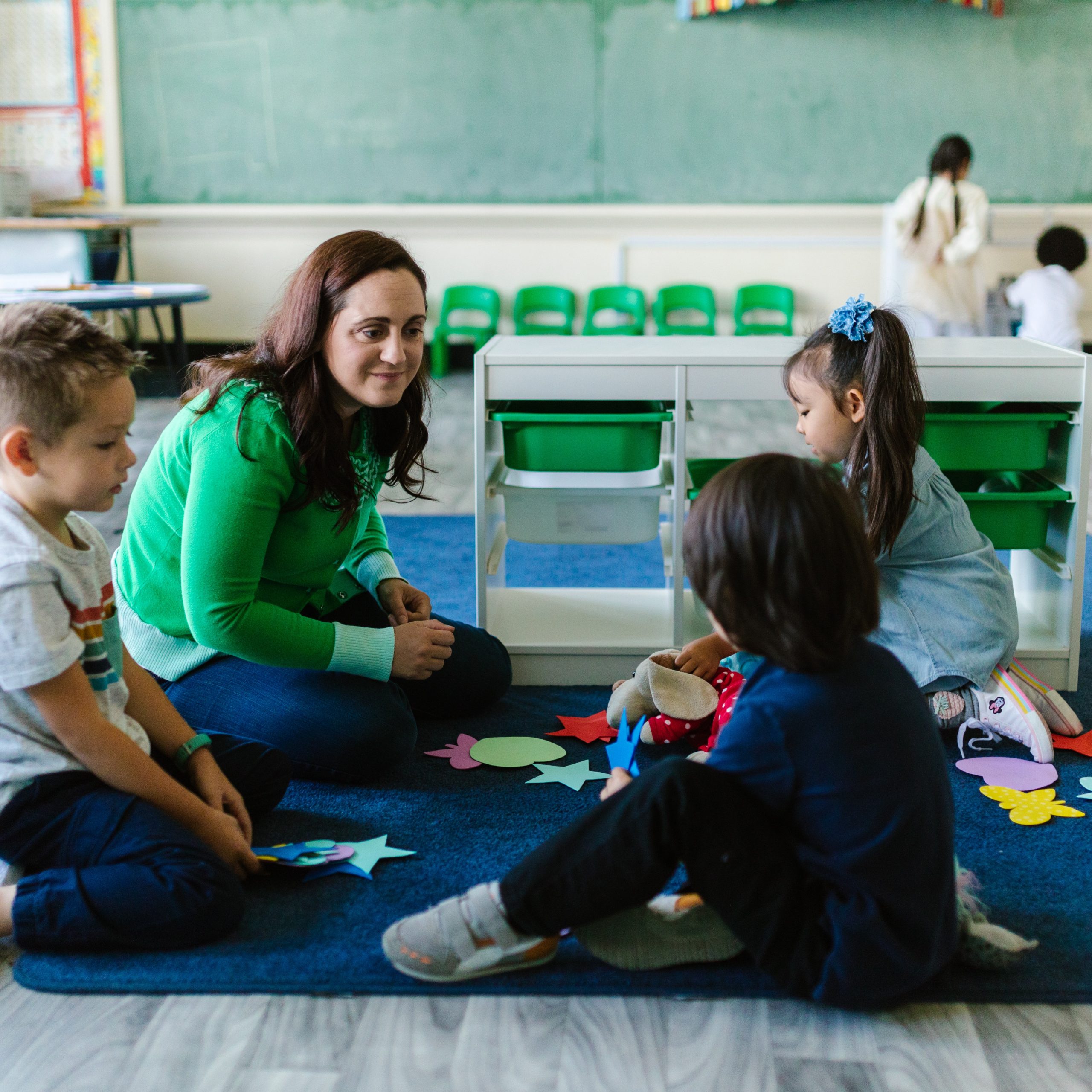 School children doing arts and crafts with school teacher.