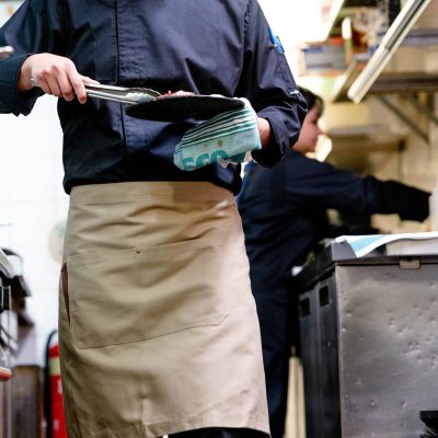 Chef wearing Black Flex Jacket and Beige Apron